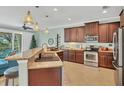 Open-concept kitchen featuring stainless steel appliances, granite countertops, and pendant lighting at 9312 Coachman Dr, Venice, FL 34293