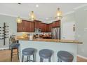 Open kitchen featuring a breakfast bar with seating, granite countertops and stainless steel appliances at 9312 Coachman Dr, Venice, FL 34293