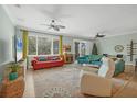 Bright living room with neutral walls, ceiling fans, large windows, and sliding glass doors to the lanai at 9312 Coachman Dr, Venice, FL 34293