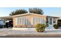 Charming manufactured home featuring a covered carport, white trim, and manicured landscaping at 937 Nettuno Dr, Venice, FL 34285