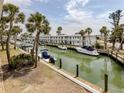 Waterfront condos with boat docks showcasing a canal view and lush tropical landscaping under a bright sky at 1001 Inlet Cir # 269, Venice, FL 34285