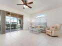 Bright living room with tile floors, ceiling fan, and sliding glass doors to a screened lanai at 1007 Gondola Park Dr # 1007, Venice, FL 34292