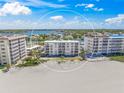 Aerial view of Bahia Mar building on the beach with stunning views of the Gulf and coastline at 1100 Tarpon Center Dr # 104, Venice, FL 34285