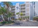 Bahia Mar building entrance with palm trees and well-maintained landscaping at 1100 Tarpon Center Dr # 104, Venice, FL 34285