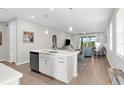 Modern open-concept kitchen with a central island featuring a sink and dishwasher at 11239 Boundless Ter, Venice, FL 34293
