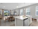 The kitchen island features stainless steel appliances and opens to the dining and living areas at 11239 Boundless Ter, Venice, FL 34293