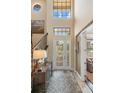 Bright foyer with high ceilings, decorative glass door, staircase and stylish console table at 1254 Cielo Ct, North Venice, FL 34275
