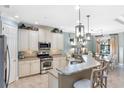 Well-lit kitchen with stainless steel appliances, granite countertops, and a breakfast bar at 1254 Cielo Ct, North Venice, FL 34275