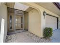 Welcoming entrance with a storm door, garden features and a carriage lantern at 131 Sandstone Cir, Venice, FL 34293