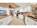 Bright kitchen featuring white cabinets, granite countertops, tile backsplash, and stainless steel appliances at 1311 Pine Needle Rd, Venice, FL 34285