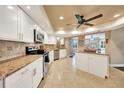 Modern kitchen with white cabinets, stainless steel appliances, granite countertops, and tile flooring at 1311 Pine Needle Rd, Venice, FL 34285