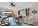 Cozy living room with a ceiling fan, entertainment center, and comfortable seating, leading to an outdoor space at 13897 Umbria St, Venice, FL 34293