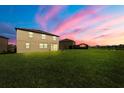 Large backyard with lush green grass, a playset, and view of the pond at 1951 E Isles Rd, Port Charlotte, FL 33953