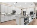 Spacious kitchen with white cabinets, stainless steel appliances, and an island at 19825 Bridgetown Loop, Venice, FL 34293