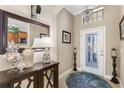 Elegant foyer with a decorative mirror, chandelier, and console table with decorative accents at 20479 Pezzana Dr, Venice, FL 34292