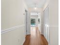Clean hallway with neutral paint, decorative trim, hardwood floors, and a glimpse of the pool at 214 Whispering Oaks Ct, Sarasota, FL 34232