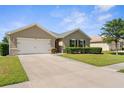 A well maintained single-story home with a spacious driveway and manicured landscaping at 25525 Lambert Ln, Punta Gorda, FL 33950