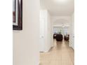 Bright hallway showcasing tile flooring that leads into a living area with comfortable leather furniture at 25525 Lambert Ln, Punta Gorda, FL 33950