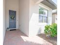 Inviting front entryway with a blue door, floral wreath, and brick walkway with lush greenery at 288 Soliera St, Nokomis, FL 34275