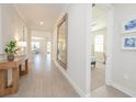 Bright hallway featuring wood-look tile floors and stylish decor, leading to an open-concept living space at 288 Soliera St, Nokomis, FL 34275
