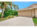 Beige home featuring a one-car garage, tile roof, and tropical landscaping in a well-maintained Florida neighborhood at 335 Auburn Woods Cir, Venice, FL 34292