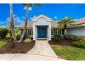 Inviting home entrance with blue double doors, manicured landscaping, and a well-maintained walkway at 351 Eden Dr, Englewood, FL 34223