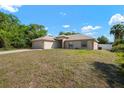 Single-story home featuring an attached two-car garage, neutral paint scheme, and established landscaping at 3590 Lookout Ln, North Port, FL 34288