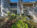 Condo exterior with sliding glass doors, a balcony, stairs and lush landscaped yard at 429 Cerromar Ln # 352, Venice, FL 34293