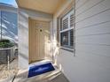 Condo front entrance with cream siding, front door and a window with hurricane shutters at 429 Cerromar Ln # 352, Venice, FL 34293