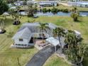 Charming waterfront home with lush landscaping, a covered carport, and easy access to the canal for boating and relaxation at 504 Buena Vista Dr, Nokomis, FL 34275