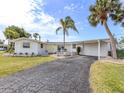 Lovely home with a carport, driveway, palm trees, a well-manicured lawn, and charming curb appeal at 504 Buena Vista Dr, Nokomis, FL 34275