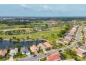Stunning aerial shot of a golf course community, featuring a serene lake and lush green landscapes at 5223 Pine Shadow Ln, North Port, FL 34287