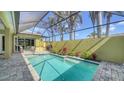 Inviting screened-in pool area with a sparkling pool, patio, and beautifully landscaped garden at 525 Cheval Dr, Venice, FL 34292
