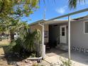 View of the side of the home featuring an outdoor seating area and covered parking at 533 Cervina N Dr # 773, Venice, FL 34285