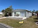 A charming home featuring a cozy front deck with outdoor seating and an easy-to-maintain lawn at 533 Cervina N Dr # 773, Venice, FL 34285