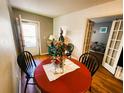 Cozy dining area featuring a red round table, three chairs, and a door to the exterior at 616 Guild Dr # 2, Venice, FL 34285
