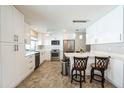 Bright white kitchen featuring stainless steel appliances, ample storage, and a convenient breakfast bar at 8432 Culebra Ave, North Port, FL 34287