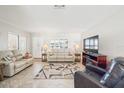 Inviting living room featuring neutral tones, stylish decor, and a large television for entertainment at 8432 Culebra Ave, North Port, FL 34287