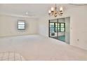 Bright living room featuring neutral carpeting, ceiling fan, chandelier and access to the lanai at 846 Senda Plata # 26, Venice, FL 34293
