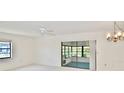 Open living space with carpet, ceiling fan, chandelier and sliding glass doors to the outdoor patio at 846 Senda Plata # 26, Venice, FL 34293