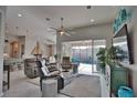 Bright, open-concept living room with modern furniture, a large ceiling fan, and views of the screened-in pool area at 863 Southland Rd, Venice, FL 34293