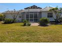 A serene backyard featuring a screened-in porch surrounded by lush landscaping at 926 Inlet Cir, Venice, FL 34285