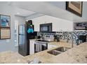 This kitchen features granite countertops, tiled backsplash, stainless steel appliances, and bright white cabinets at 934 Wexford Blvd # 934, Venice, FL 34293
