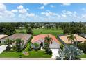 Stunning aerial view of a home with a red tile roof backing onto a lush green golf course at 1028 Grouse Way, Venice, FL 34285