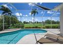 Relaxing screened-in pool with lounge chairs and a scenic view of the golf course at 1028 Grouse Way, Venice, FL 34285
