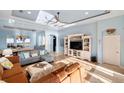 Bright living room with tray ceilings, tile floors, and an open floor plan to the dining room at 109 Montelluna Dr, North Venice, FL 34275