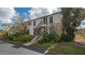 Exterior view of a well-maintained condominium with lush landscaping and covered stairs at 1130 Bird Bay Way # 184, Venice, FL 34285