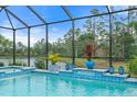 Inviting pool area features tiled accents, water features, and relaxing views of mature trees at 12456 Destin Loop, Venice, FL 34293