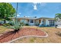 Charming home with lush, tropical landscaping and shutters under a beautiful sunny sky at 1281 Wilson Dr, Englewood, FL 34224