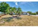 Charming single-story home with lush, tropical landscaping in the front yard with a long driveway at 1281 Wilson Dr, Englewood, FL 34224